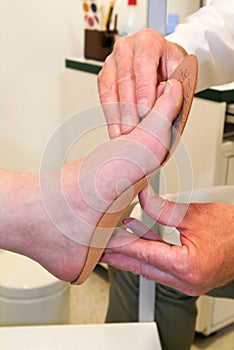 Doctor preparing orthopedic insoles for a patient