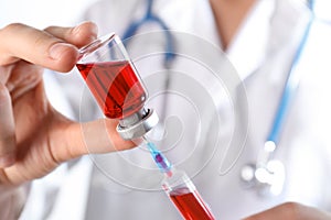 Doctor preparing syringe for injection, closeup