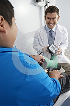 Doctor Preparing To Check Boy's Blood Pressure