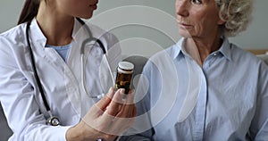 Doctor prescribing drugs at health consultation to old woman.