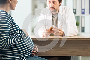 Doctor prescribing pills to pregnant woman