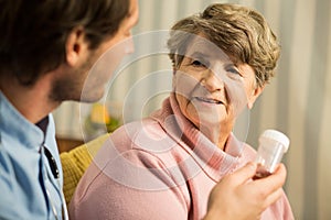 Doctor prescribing senior woman medicament photo
