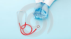 Doctor presenting empty hands, blank palm and red stethoscope on blue color background. Doctor or nurse holding virtual object
