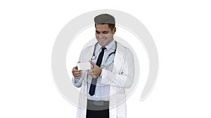 Doctor presenting vitamins and talking about them to camera on white background.