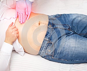 The doctor probes the epigastric region on the abdomen of a patient with pain and inflammation. Stomach and duodenal photo