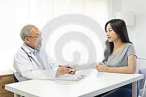 Doctor in professional uniform examining young patient woman at hospital or medical clinic. Health care