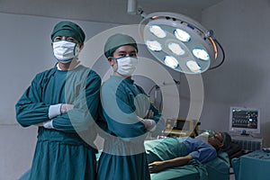 Doctor Professor Smiling surgeon crossing his arms while standing in a surgical room