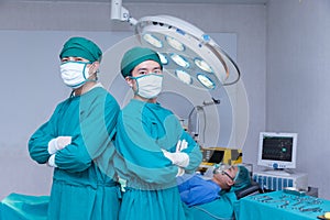Doctor Professor Smiling surgeon crossing his arms while standing in a surgical room photo