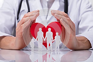 Doctor Protecting Family Cut Out With Heart Shape