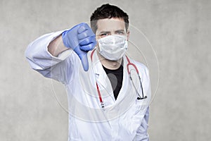 Doctor in protective clothing shows thumb down