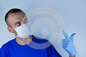 Doctor in a protective mask on a blue background. Thinking holding hand in glove near mouth.copyspace for text