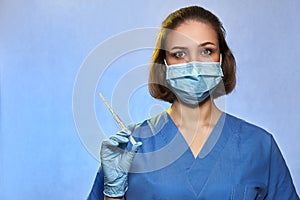 Doctor in protective mask and blue latex gloves with syringe with a medicine vaccine from Coronavirus