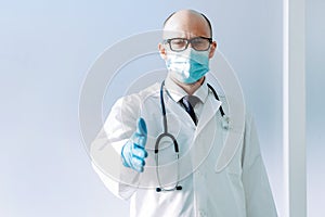 doctor in a protective mask holding out his hand for a handshake .
