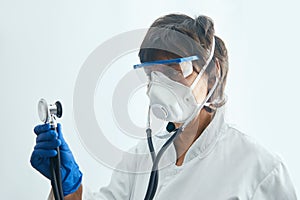 Doctor in protective mask preparing to examine his patient with a stethoscope copy space healthcare medicine occupation people wor
