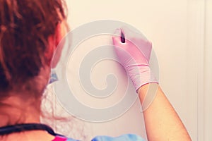 A doctor in protective medical gloves knocks on the apartment door