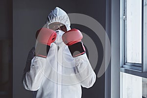 Doctor in protective suit with boxing gloves