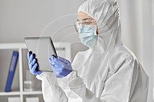 Doctor in protective wear with tablet computer