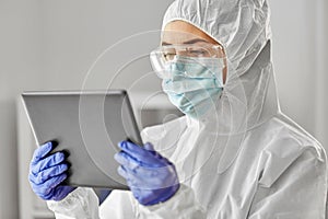 Doctor in protective wear with tablet computer