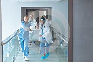 Doctor pushing emergency stretcher bed in corridor at hospital