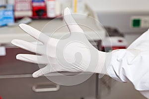 Doctor puts on latex gloves. photo
