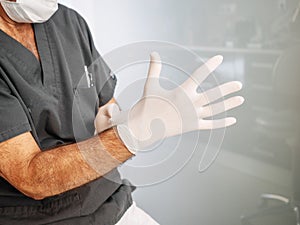 Doctor puts on latex gloves before proceeding to perform his work photo