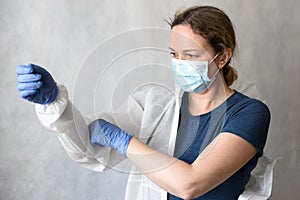 Doctor puts on personal protective equipment PPE due to COVID-19