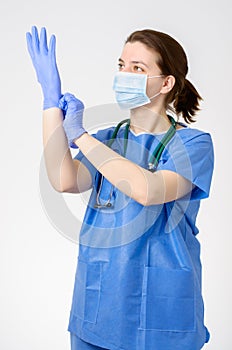 Doctor putting on blue surgical gloves