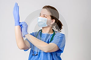 Doctor putting on blue surgical gloves