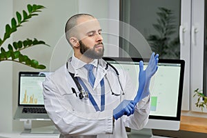 A doctor putting on a disposable medical glove preparing to examine a patient