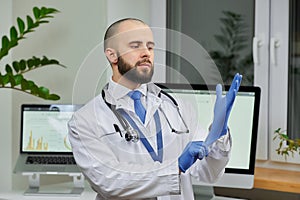 A doctor putting on a disposable medical glove preparing to examine a patient