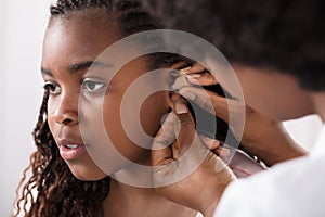 Doctor Putting Hearing Aid In Patient`s Ear