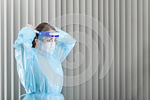 Doctor putting on personal protection equipment at hospital