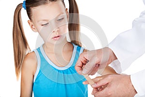 Doctor putting plaster on finger isolated on white background.