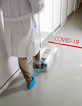 Doctor putting protective shoes on in hospitaly