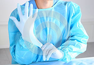 Doctor putting on sterile gloves isolated white