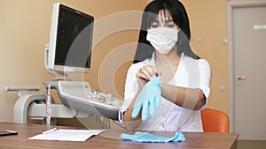 Doctor putting sterile gloves while preparing for operation sitting at the table in her office. Shot in 4k