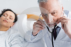 doctor putting on stethoscope near sick