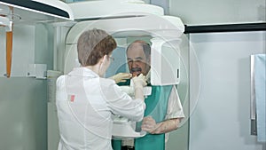 Doctor or radiologist helping senior man doing computer analyses of teeth