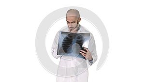 Doctor radiologist looking at x-ray scan walking on white background.
