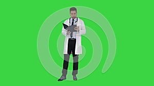 Doctor reading Medical Report of Patient or Recepie or Text book on a Green Screen, Chroma Key.