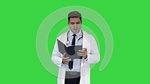 Doctor reading Medical Report of Patient or Recepie or Text book on a Green Screen, Chroma Key.