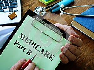 Doctor reads medicare part b basics on a clipboard