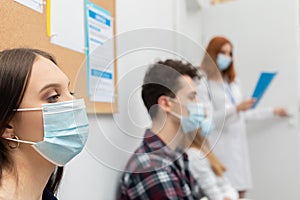 The doctor reads out the next person in line. During a pandemic, everyone must wear protective masks. Close-up shot