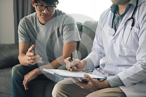 Doctor is recording the patient`s information while the patient is explaining