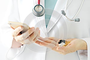 Doctor research medicine on mobile, Doctor hand holding smartphone and pills.