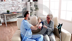 Doctor in retirement home measuring the blood pressure