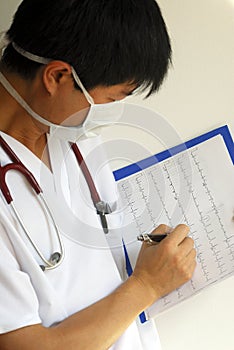 A doctor reviews the patientâ€™s EKG chart