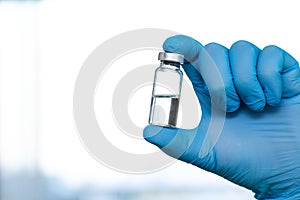 Doctor in rubber gloves holding coronavirus COVID-19 vaccine. Healthcare And Medical concept