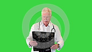 Doctor in a rush viewing MRI scans while walking on a Green Screen, Chroma Key.