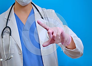 A doctor`s finger in medical gloves presses a virtual button, copy space for text. Nurse in white medical gown with raised hand,